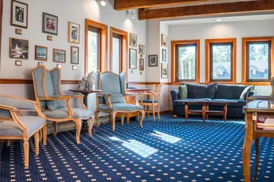 a waiting room with chairs and a couch and tables at Painter's Lodge in Campbell River