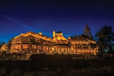 a large house is lit up at night at Painter's Lodge in Campbell River