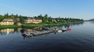 a group of boats docked at a dock on a river at Painter's Lodge in Campbell River