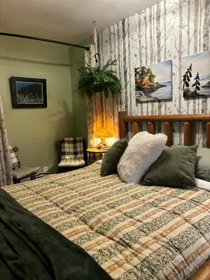 a bedroom with a bed with a comforter at Sea 'N' Stars BNB in Gabriola