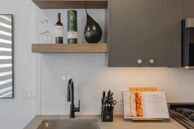 a kitchen counter with a sink and bottles of wine at Upper and Lower, Great for Large Families, Fenced Yard in Calgary