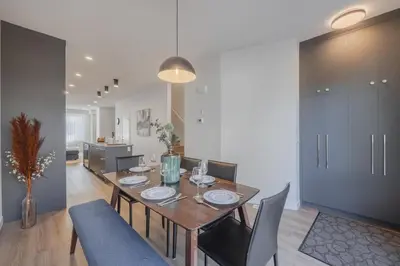 a dining room with a wooden table and chairs at Upper and Lower, Great for Large Families, Fenced Yard in Calgary