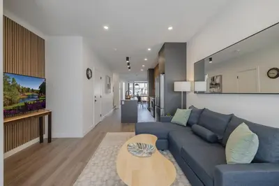 a living room with a blue couch and a table at Upper and Lower, Great for Large Families, Fenced Yard in Calgary