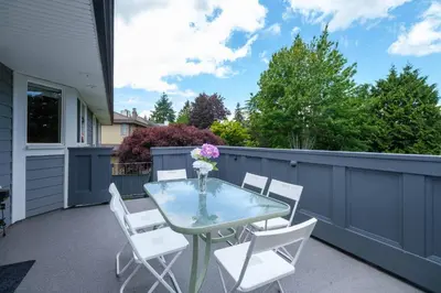 a patio with a glass table and white chairs at Surrey Family Home w/ Patio & Garden – 3BR 2BA in Surrey