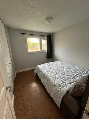 a bedroom with a bed and a window at Cozy Riverdale Home in Whitehorse