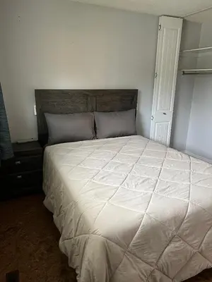 a bedroom with a large bed with a white comforter at Cozy Riverdale Home in Whitehorse