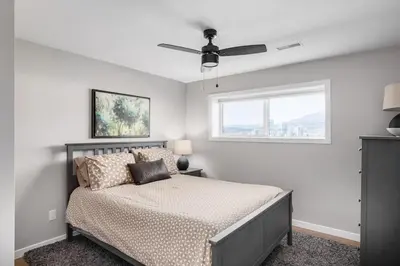 a bedroom with a bed with a ceiling fan at Knox Mountain Vista 2 Bdrm Suite in Kelowna