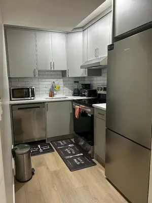 a kitchen with stainless steel appliances and white cabinets at Eli's Place in Calgary