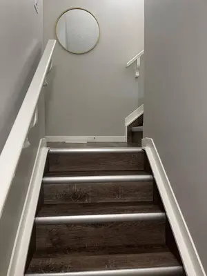 a stairway with a mirror and a circular mirror on the wall at stylish 5-Star Suite 1BD 1 Bath Le Reve Beaumont in Nisku