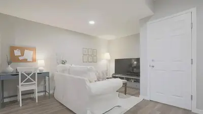 a white living room with a white chair and a desk at stylish 5-Star Suite 1BD 1 Bath Le Reve Beaumont in Nisku
