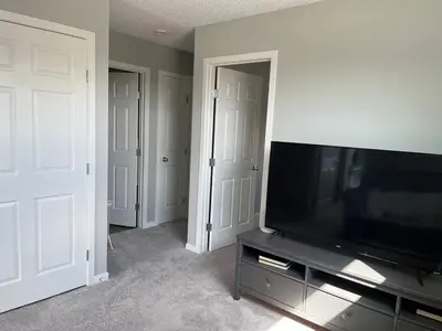 a living room with a flat screen tv on a entertainment center at Le Reve Show Home 3BD, AC, sleep 9 , Beaumont in Nisku