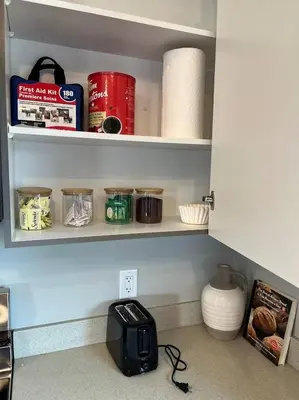 a kitchen cabinet with acomputer on the counter with food at Le Reve Show Home 3BD, AC, sleep 9 , Beaumont in Nisku
