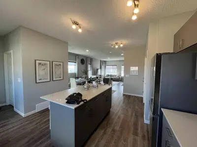 a kitchen with a large island in the middle of a room at Le Reve Show Home 3BD, AC, sleep 9 , Beaumont in Nisku