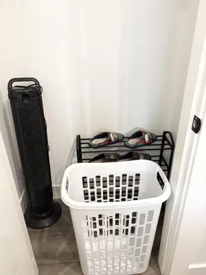 a laundry room with a white basket and a black radiator at Bird Nest Suites in Surrey