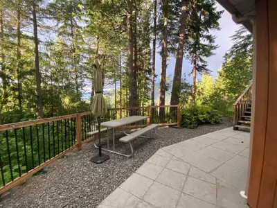 a patio with a bench and an umbrella at Blind Bay Chalet 2 Bedroom Private Suite in Blind Bay