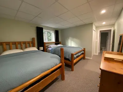 a bedroom with two beds and a desk and a table at Blind Bay Chalet 2 Bedroom Private Suite in Blind Bay