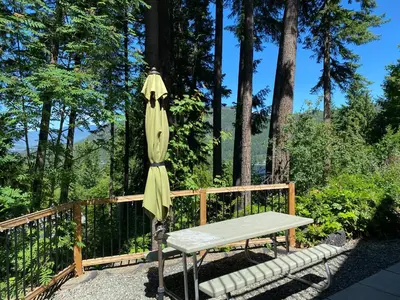 a bench and an umbrella next to a fence at Blind Bay Chalet 2 Bedroom Private Suite in Blind Bay