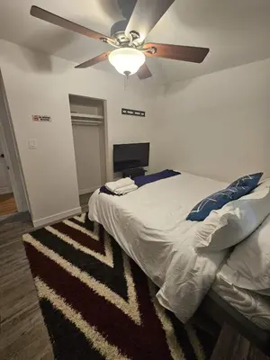 a bedroom with a bed with a ceiling fan at Aansel Suites 2 bedroom in Edmonton