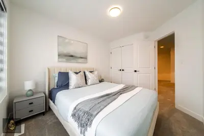 a bedroom with a large white bed and a white cabinet at FreshModernWEMGarageKingBed in Edmonton