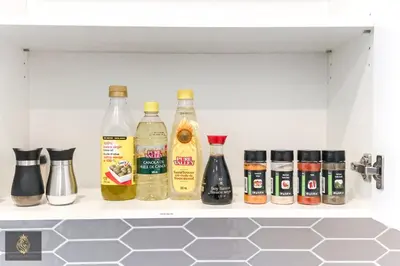 a shelf with several bottles of alcohol and spices at FreshModernWEMGarageKingBed in Edmonton