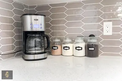 a row of jars on a counter next to a coffee maker at FreshModernWEMGarageKingBed in Edmonton