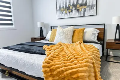 a bedroom with a bed with a blanket on it at FreshModernWEMGarageKingBed in Edmonton