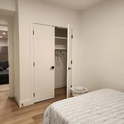 a bedroom with a white closet and a bed at Spacious 2 Bedroom Suite in Gorman, Edmonton, Canada in Edmonton