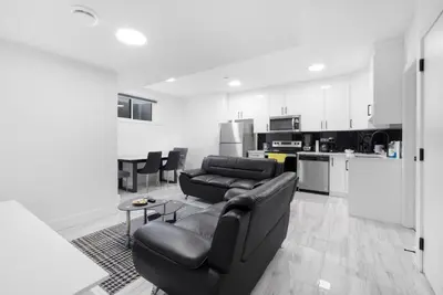 a living room with a couch and a kitchen at Spacious 2 Bedroom Suite in Edmonton, Canada in Edmonton