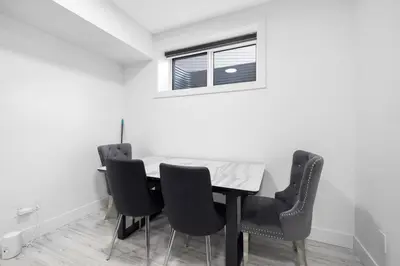 a dining room table with black chairs and a window at Spacious 2 Bedroom Suite in Edmonton, Canada in Edmonton