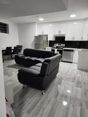 a living room with two couches and a kitchen at Spacious 2 Bedroom Suite in Edmonton, Canada in Edmonton