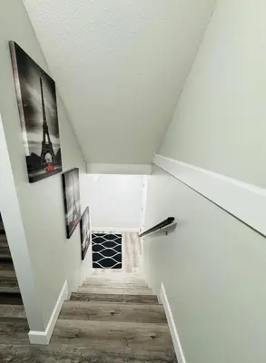 a staircase in a attic with pictures on the walls at True Haven in Prince George