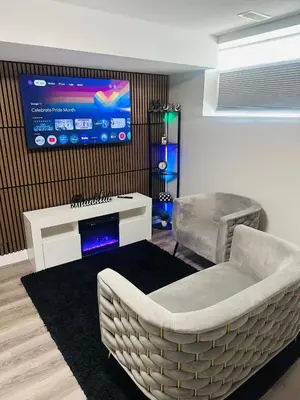 a living room with a couch and a tv on a wall at True Haven in Prince George