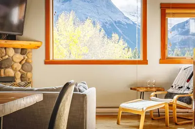 a living room with a view of a mountain at Ha Ling Haven - Penthouse with Shared Rooftop Hot Tub in Canmore
