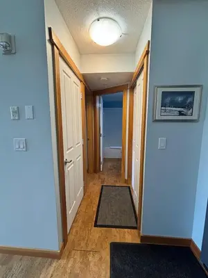 a hallway of a home with blue walls and a door at Ha Ling Haven - Penthouse with Shared Rooftop Hot Tub in Canmore