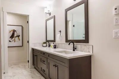 a bathroom with a sink and two mirrors at Creekside Elegance at Timberstone in Canmore