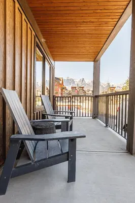 two chairs sitting on the porch of a house at Creekside Elegance at Timberstone in Canmore