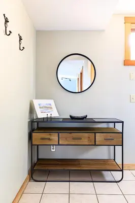 a dressing table with a mirror on a wall at Boardwalk Bliss - Top Floor Downtown Condo in Canmore