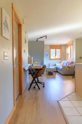 a living room with a desk and a couch at Boardwalk Bliss - Top Floor Downtown Condo in Canmore