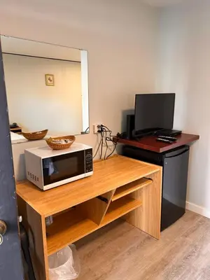 a microwave sitting on top of a wooden table at Lakecity Inn in Penticton