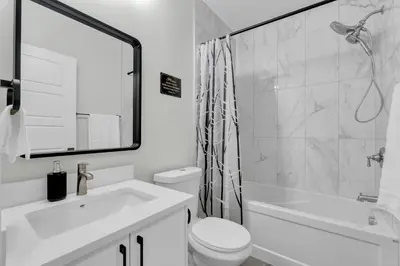 a white bathroom with a toilet and a sink at Cozy Luxe Suite in Calgary