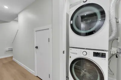 a washer and dryer in a white laundry room at Cozy Luxe Suite in Calgary