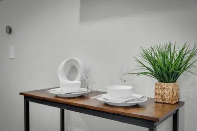 a table with dishes and a potted plant on it at Cozy Luxe Suite in Calgary