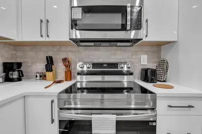 a kitchen with a stainless steel stove and a microwave at Cozy Luxe Suite in Calgary