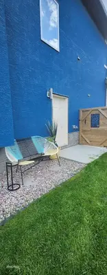 a patio with a bench and a blue wall at The Vaulted Oasis 2-bedroom with a Garden in Airdrie
