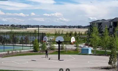 a person is playing basketball on a basketball court at The Vaulted Oasis 2-bedroom with a Garden in Airdrie
