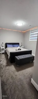 a bedroom with a large bed and a couch at The Vaulted Oasis 2-bedroom with a Garden in Airdrie