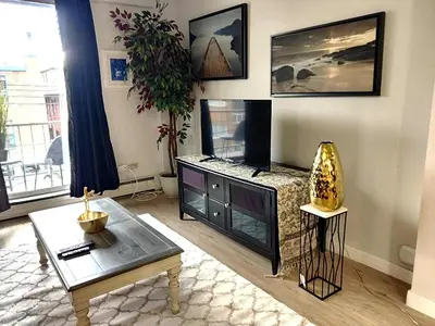 a living room with a fireplace and a table at Stay Heart of Calgary, Enjoy Night Life, Free Parking Incl in Calgary