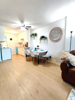 a living room with a table and chairs and a kitchen at Stay Heart of Calgary, Enjoy Night Life, Free Parking Incl in Calgary