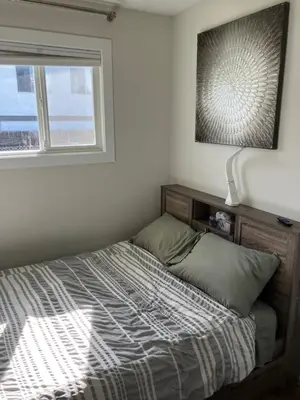 a bed sitting in a bedroom with a window at Welcome to the Cozy Studio in Kelowna