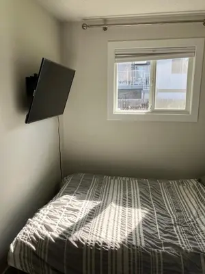 a bedroom with a bed and a window at Welcome to the Cozy Studio in Kelowna